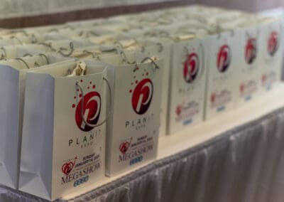 A row of gift bags on a table featuring the Plan it Expo logo and text MEGASHOW 2020.